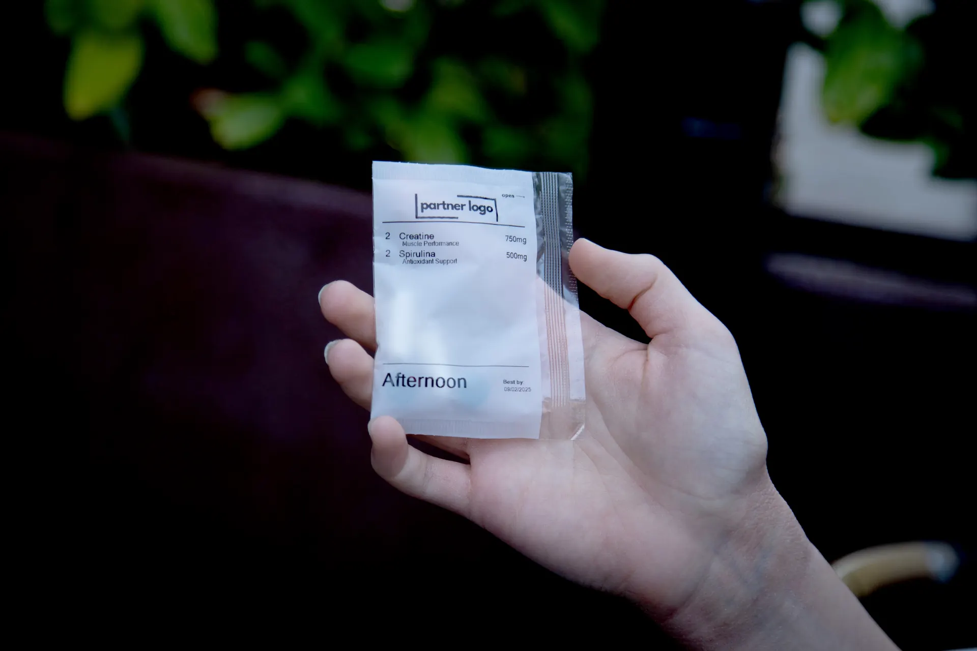 An afternoon pack, printed with a practice's own logo, held in a patient's hand